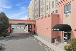 L’entrée d’un hôtel, avec un panneau indiquant une voie dégagée, une zone de stationnement et la façade du bâtiment.