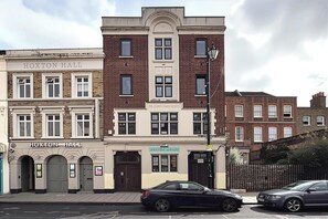 A street view with a building labeled 'HOXTON HALL' and 'THE QUEEN NARY HOSTEL' with a brick facade and multiple windows.