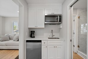 A modern kitchen with white cabinetry, a built-in microwave, and a dishwasher. - Sunset Retreat at the Lake | Sleeps 24 | Pool & Hot Tub (Sherrills Ford)