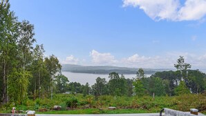A bench overlooking a lake with a forested area in the foreground and hills in the distance. - Gorgeous home in Villands with lake view (Villands)