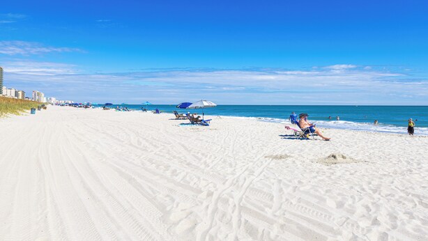 A sandy beach with clear skies and a few people. - Beachside Bliss • Pool • Near Beach & Attractions (North Myrtle Beach)