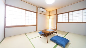 A traditional Japanese room with tatami flooring, a low wooden table, and a blue pillow. - Miraie Yokkaichi Aobacho (Yokkaichi)