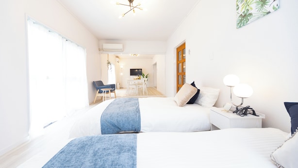 A hotel room with two beds, a desk, a chair, and a TV in the background. - Miraie Yokkaichi Aobacho (Yokkaichi)
