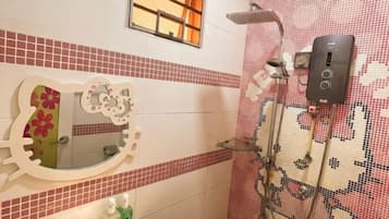 A bathroom with a mirror, tiled walls, a shower, and a control panel.