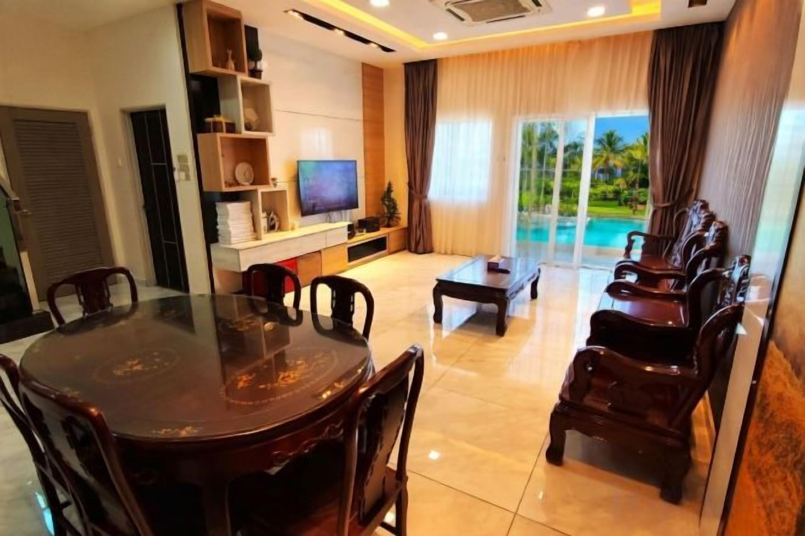 A modern living room with a dining table, chairs, a sofa, and a TV.
