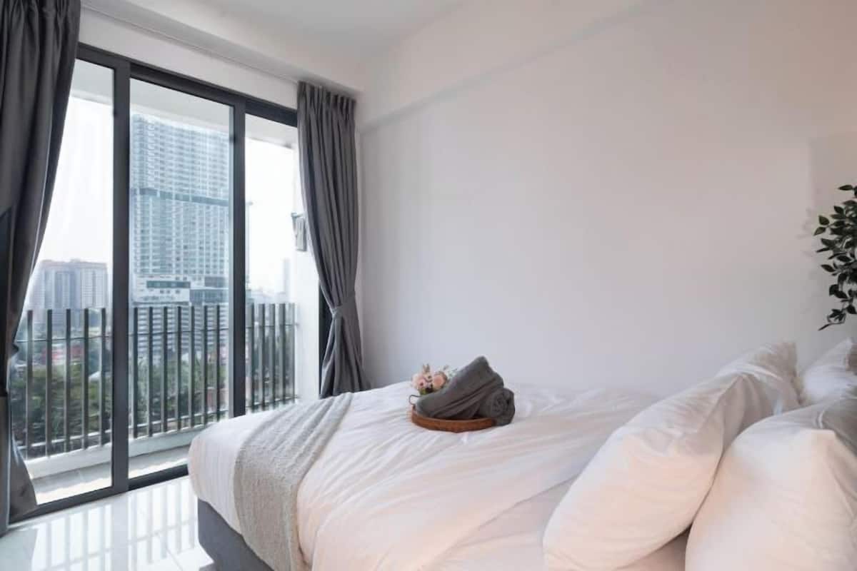 Een slaapkamer met een groot raam, een bed en een plant.