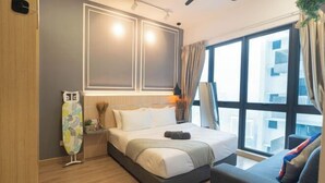 Quarto de hotel moderno com cama, sofá, janela com vista e TV na parede.