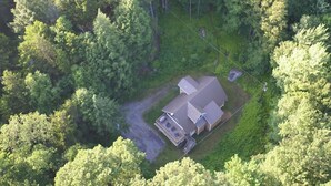 Eine Vogelperspektive eines Hauses, das von dichtem Wald umgeben ist.