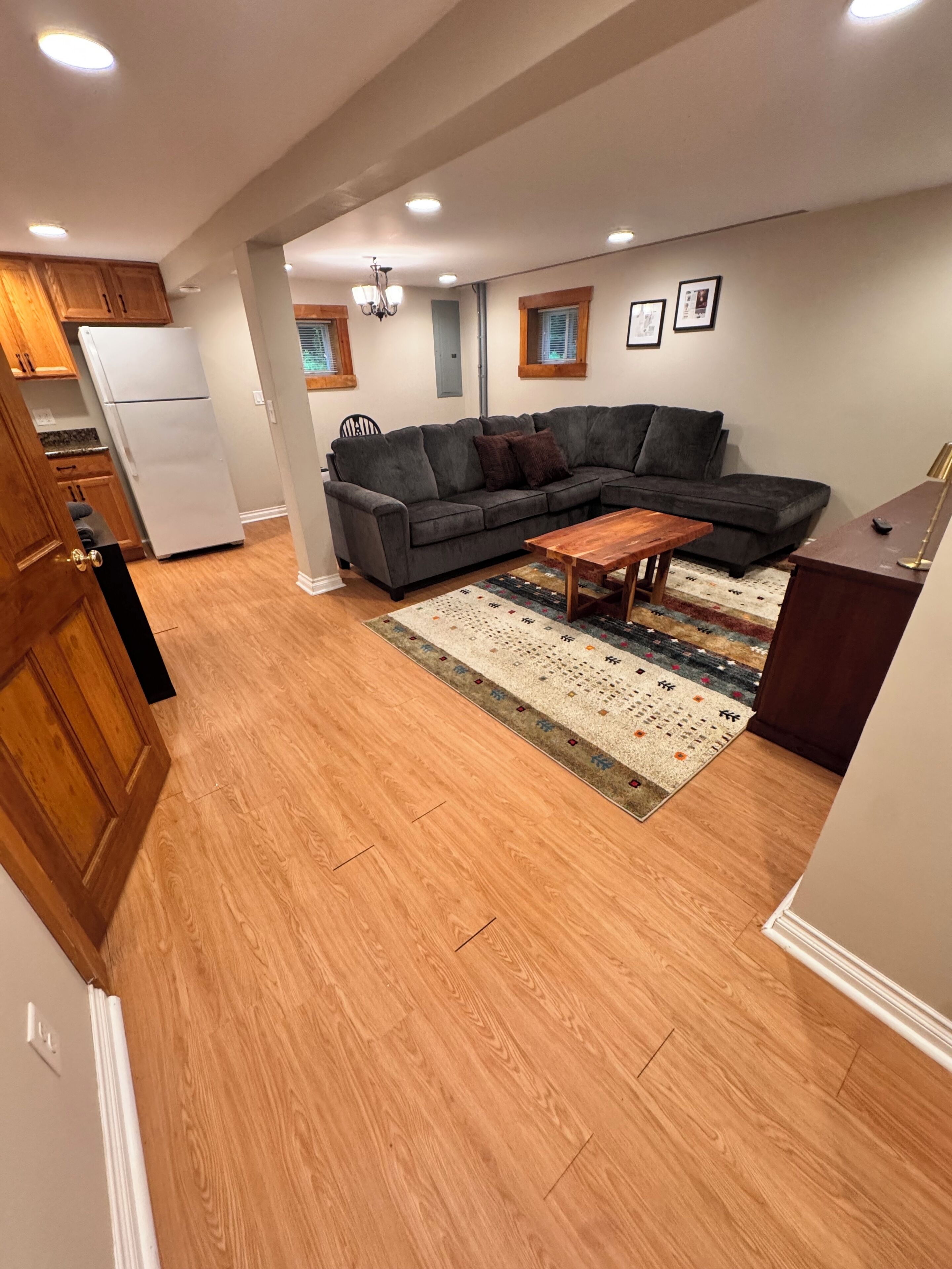 A modern living room with a sectional sofa, a wooden coffee table, and a patterned rug.
