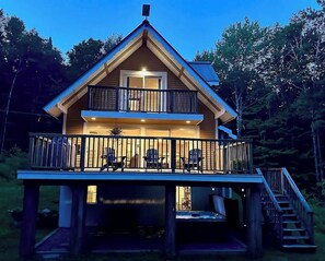 Une cabane à deux étages dotée d’un balcon, d’un escalier et d’une terrasse.