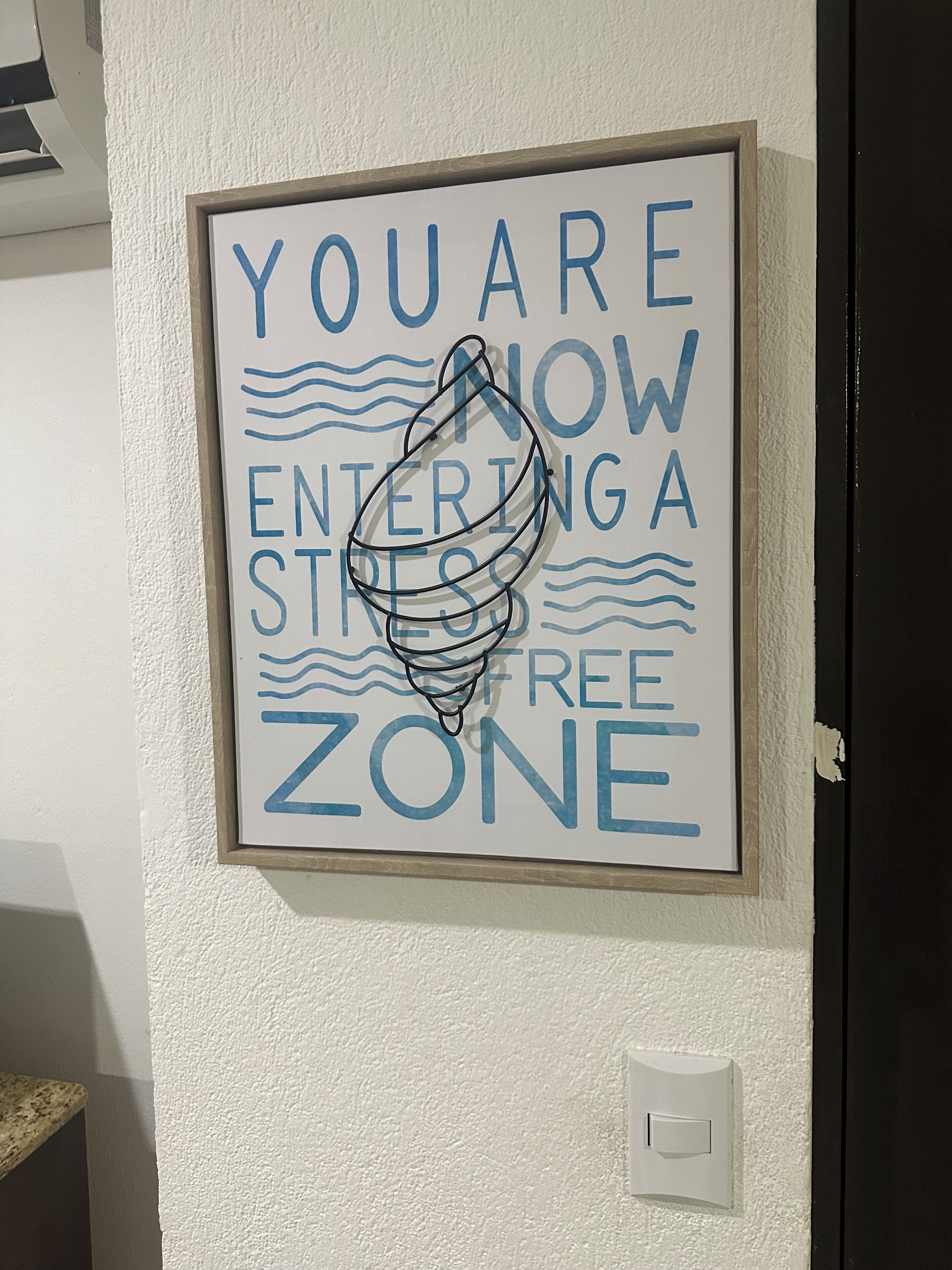 Un cartel enmarcado en una pared con el texto 'AHORA ENTRANDO EN UNA ZONA LIBRE DE RIESGOS'.