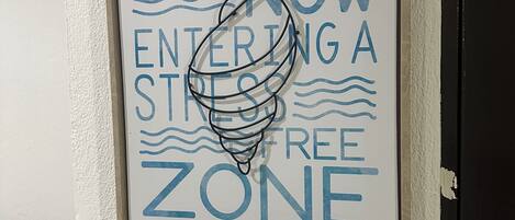Un cartel enmarcado en una pared con el texto 'AHORA ENTRANDO EN UNA ZONA LIBRE DE RIESGOS'.