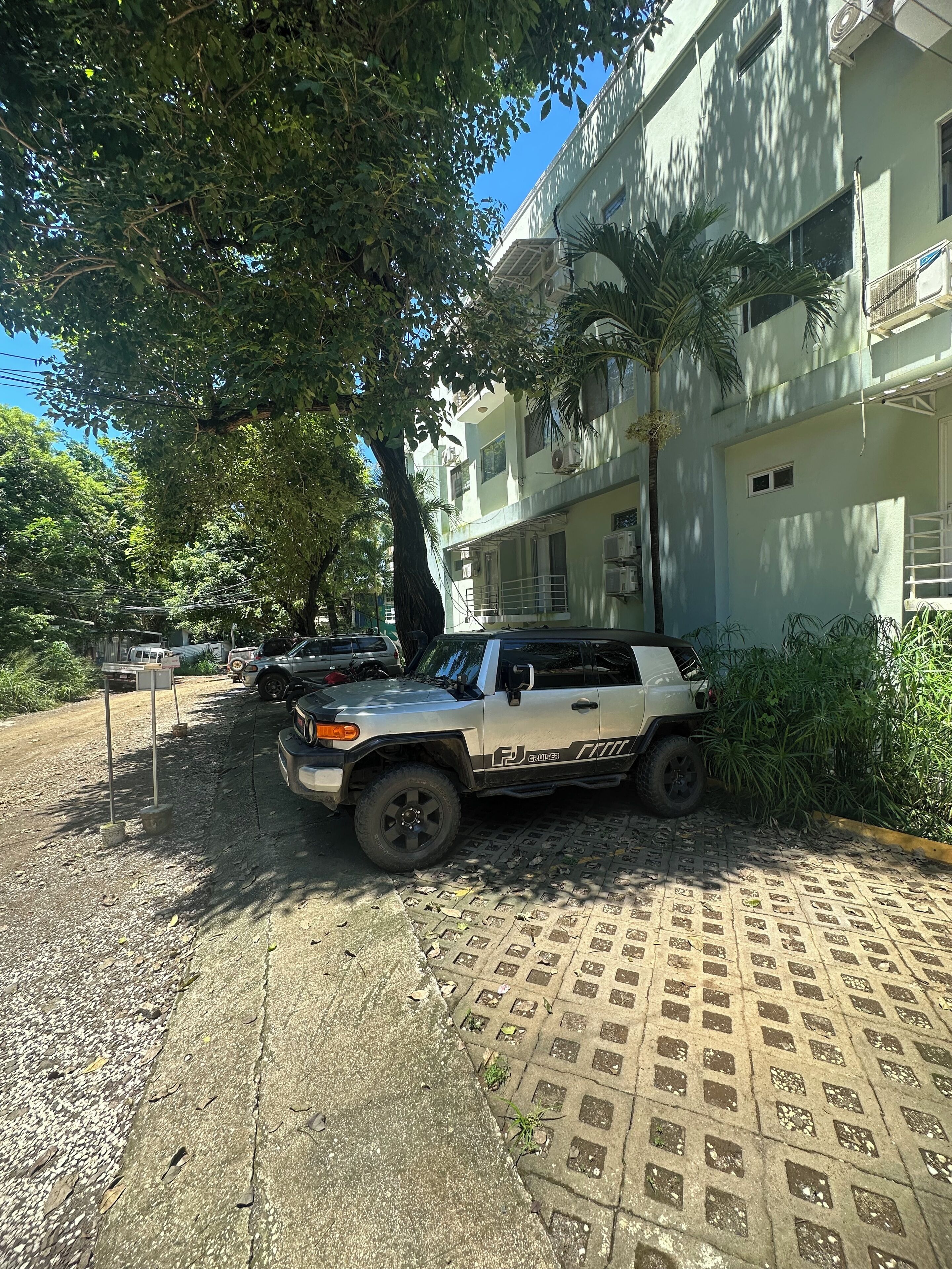 A vehicle parked on a paved area with a building in the background.