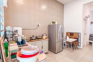 A compact kitchen with a refrigerator, a sink, and a dining area with chairs. - Golden Sweet Home @ CH Golden Hills (Night Market) - 2 Storey Terrace House (Brinchang)