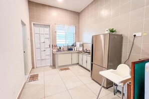 A compact kitchen with a refrigerator, a sink, and a window with blinds. - Golden Sweet Home @ CH Golden Hills (Night Market) - 2 Storey Terrace House (Brinchang)