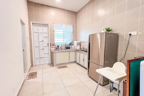 A compact kitchen with a refrigerator, a sink, and a window with blinds. - Golden Sweet Home @ CH Golden Hills (Night Market) - 2 Storey Terrace House (Brinchang)