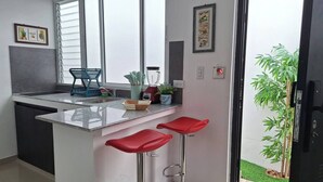 Una cucina moderna con angolo bar, lavandino e finestra con persiane.