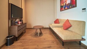 Un salon moderne avec un canapé, une table basse et un téléviseur posé sur un meuble en bois.