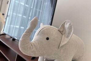 Un éléphant en peluche est posé sur une surface en bois.