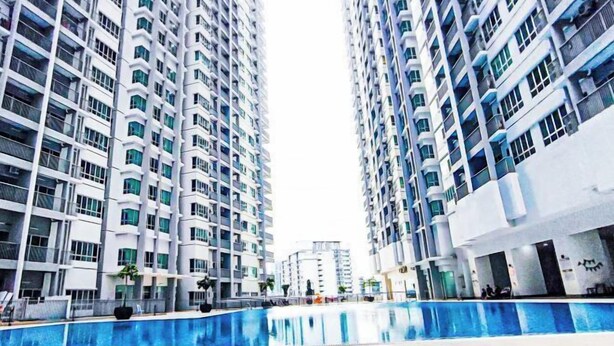 A high-rise residential building with multiple balconies and a swimming pool area.