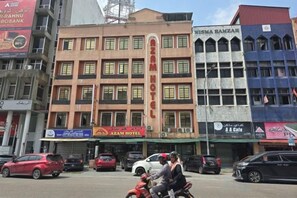 A building with multiple floors, a sign for 'Azam Hotel' on the ground floor, and a 'Rahnun Bank' sign above. - Hotel O Kota Bharu Near War Museum Formerly Azam Hotel (Kota Bharu)