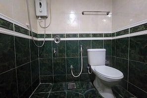 Kylpyhuone, jossa on wc, suihku ja käsienkuivaaja.