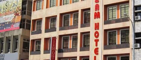 A multi-story building with a prominent sign for Azam Hotel.