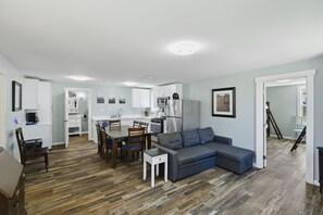 A modern apartment with a dining area, kitchen, and living room.