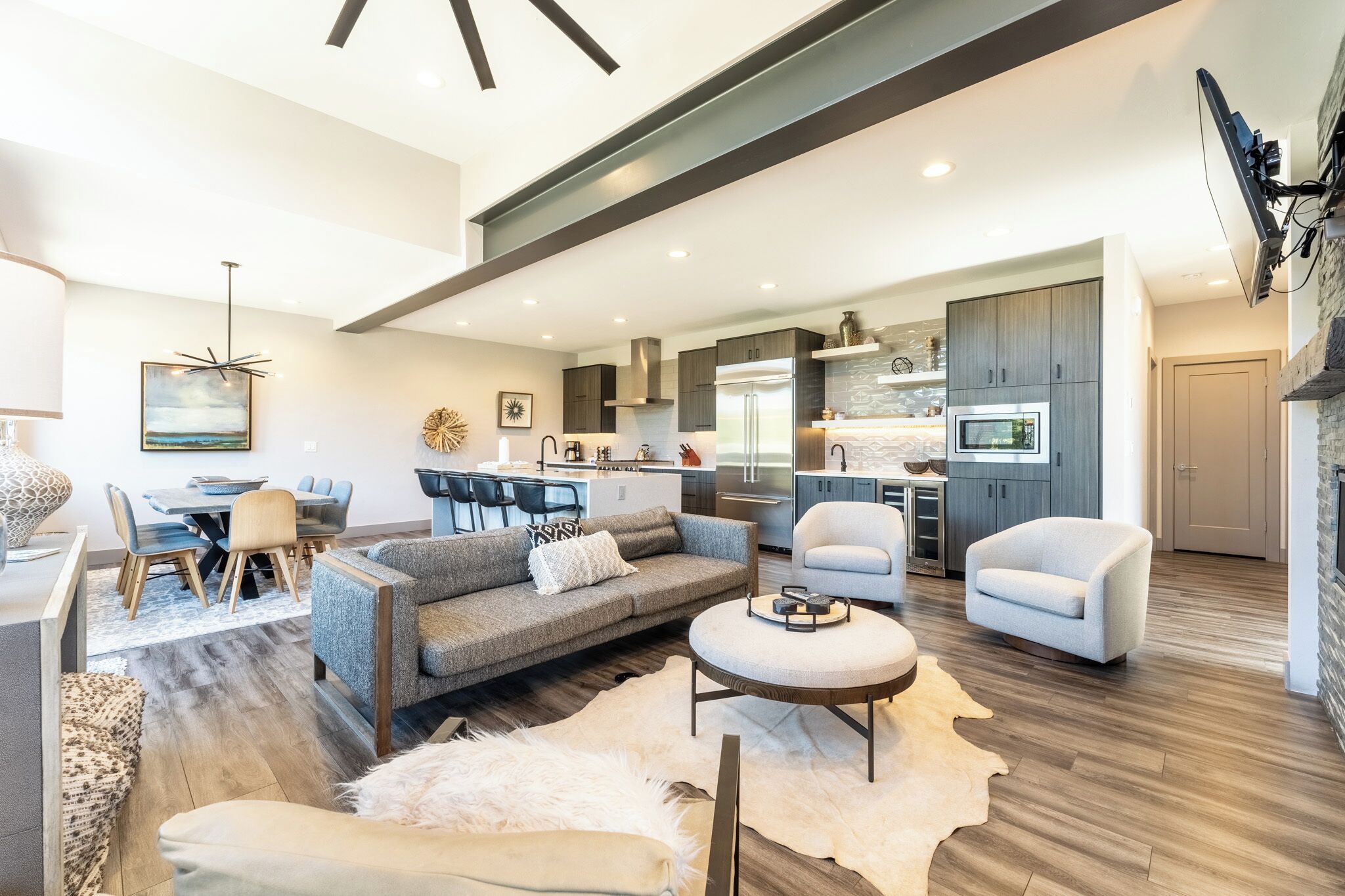 A spacious living area with a sofa, armchairs, and a coffee table.