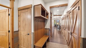 A hallway with wooden doors and a bench. - Wm102cf-2 (Frisco)