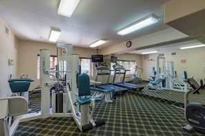 A gym with exercise equipment, a mirror, and a clock on the wall. - Gateway #5028 (Keystone)