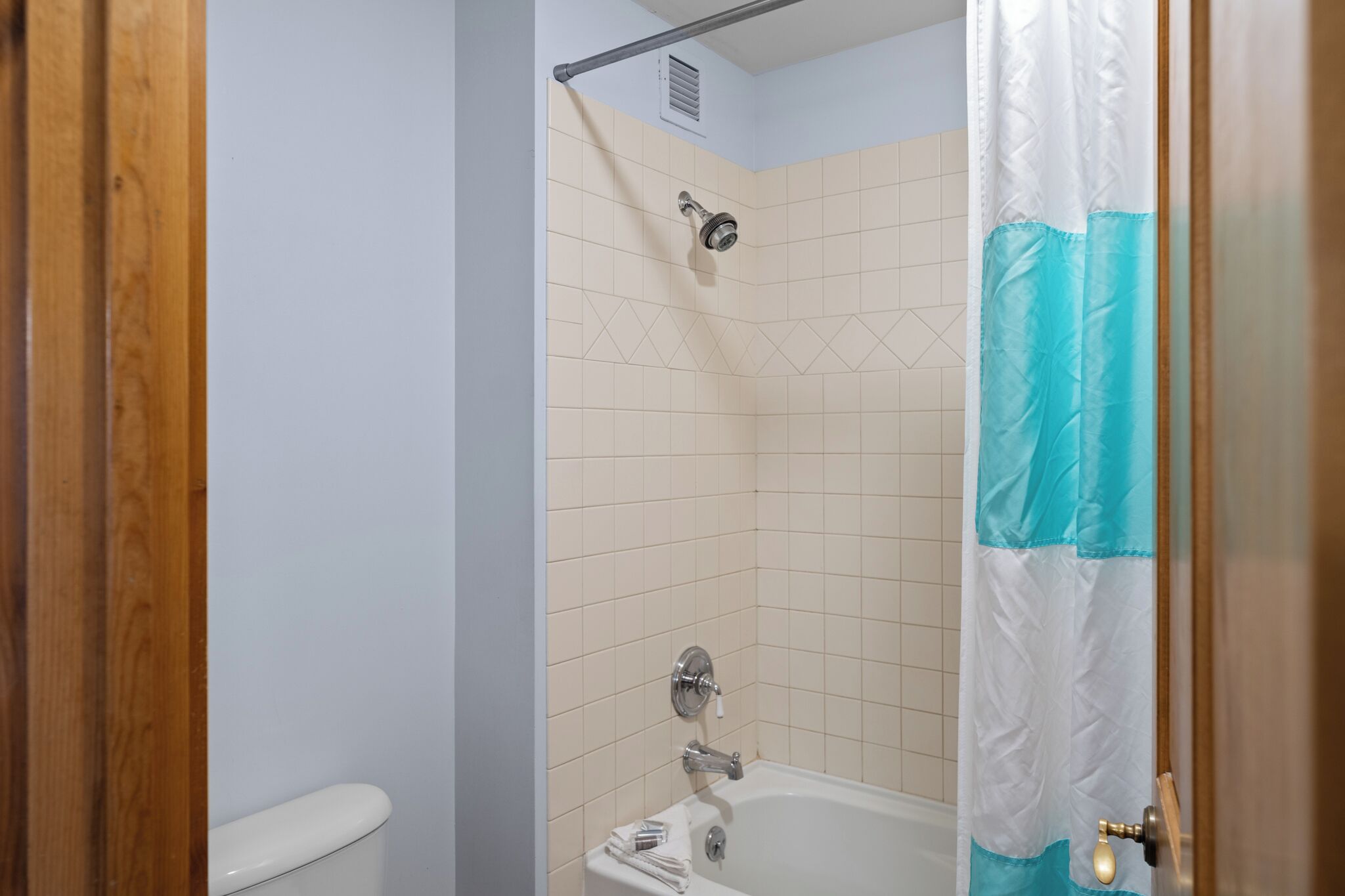 A bathroom with a shower, toilet, and bathtub.
