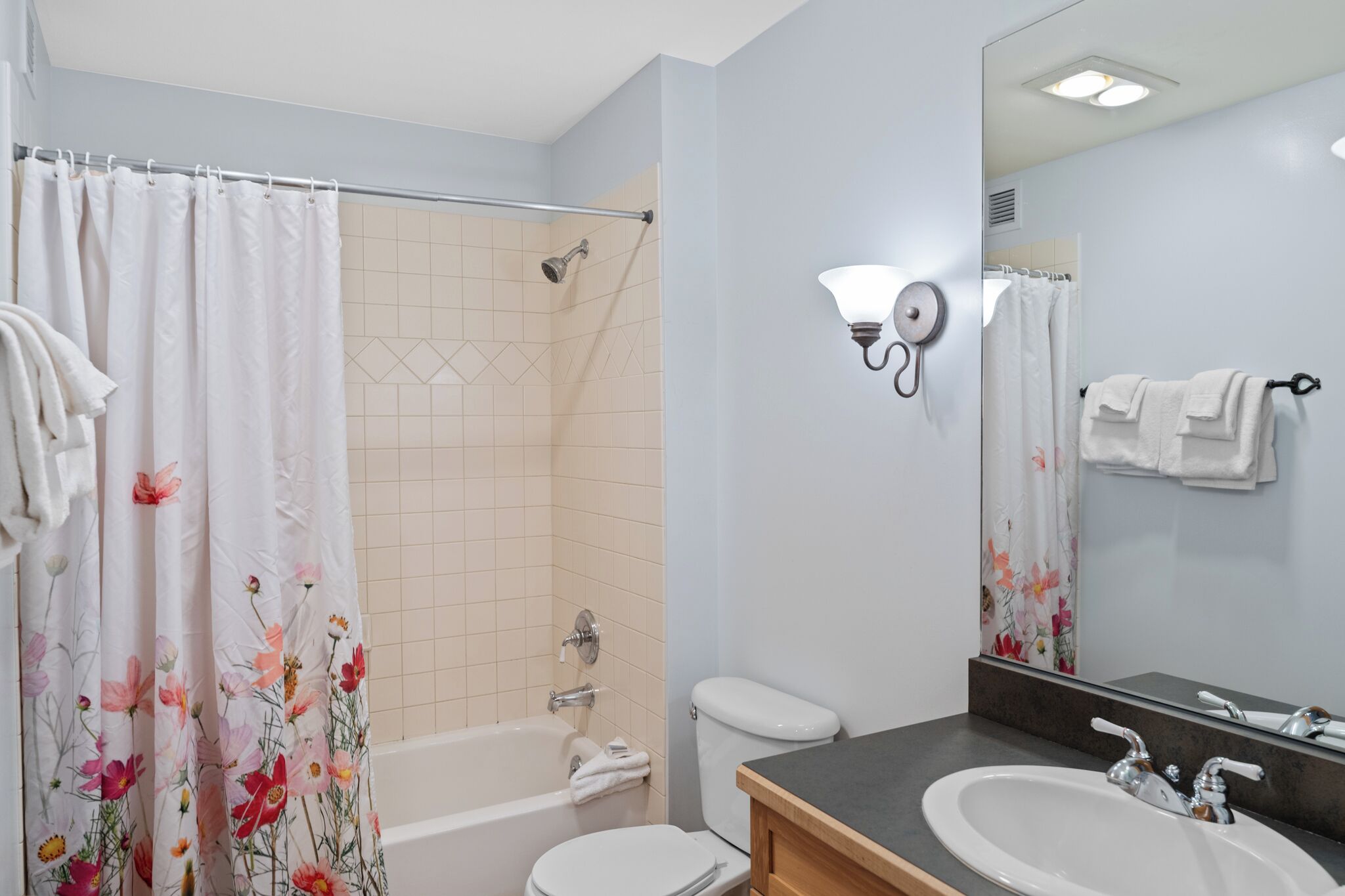 Un baño con bañera, inodoro y dos lavabos.