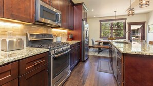 A modern kitchen with stainless steel appliances, wooden cabinets, and granite countertops. - A747-4 (Keystone)