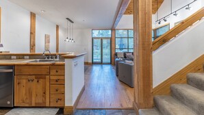 A modern kitchen with wooden cabinets, a built-in dishwasher, and a large window. - St8715-2 (Keystone)