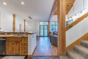 A modern kitchen with wooden cabinets, a built-in dishwasher, and a large window. - St8715-2 (Keystone)