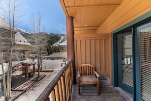 A wooden deck with a chair, a covered area, and a view of a snowy mountain. - Al81101 (Keystone)
