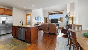 A spacious kitchen with a central island, wooden cabinets, and stainless steel appliances. - A39-3 (Keystone)