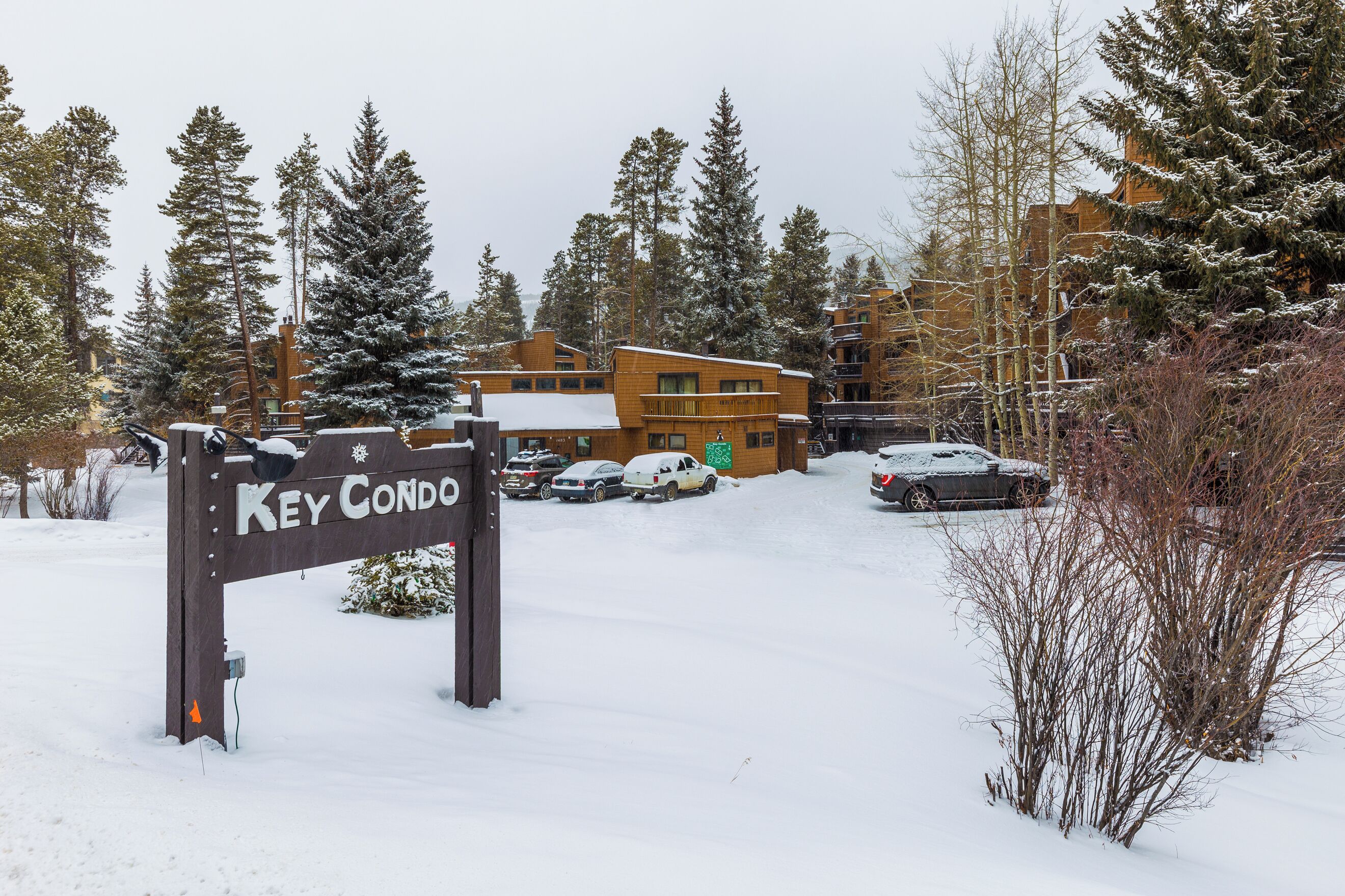 A snow-covered parking lot with a sign reading "Key Condo."