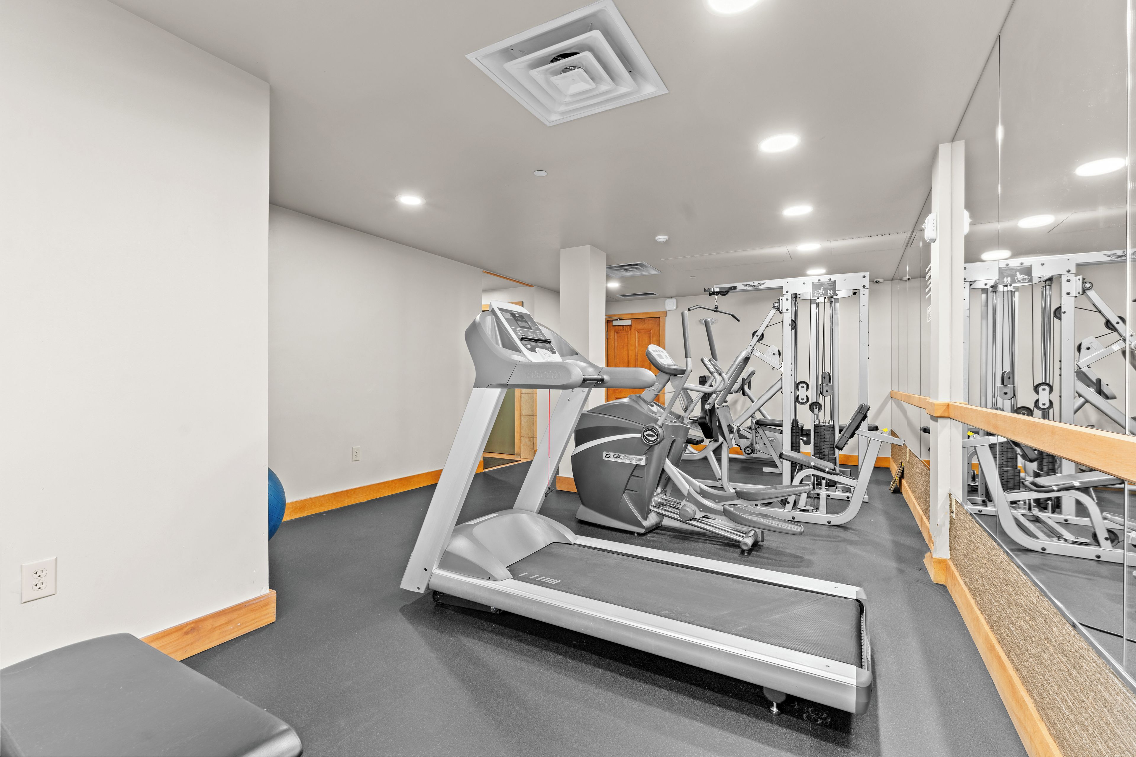 A gym with treadmills, elliptical machines, and weight equipment.