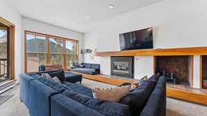 A spacious living room with a large sofa set, a fireplace, and a flat-screen TV mounted above it. - Qs1645-2 (Keystone)