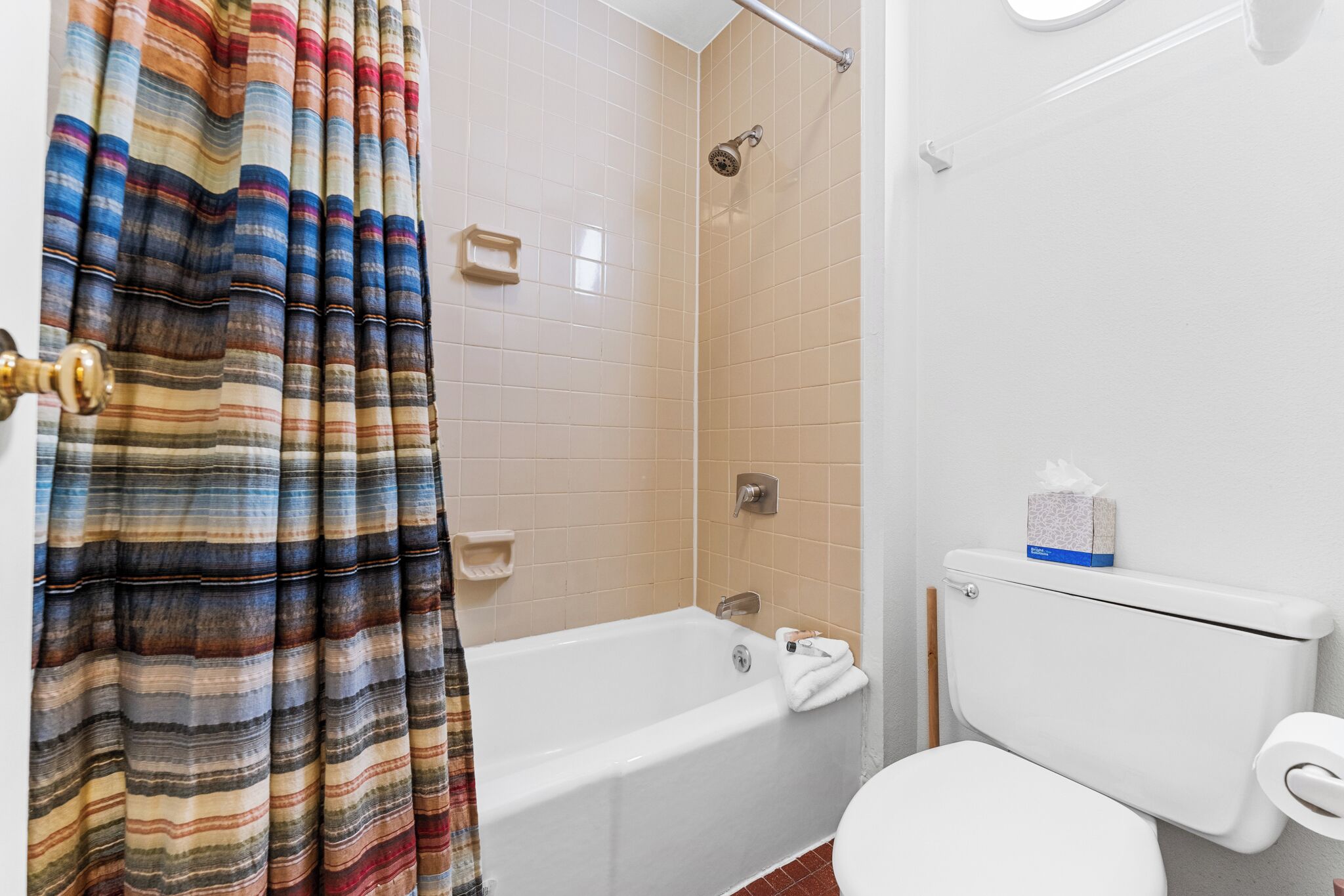 Un baño con bañera, inodoro y cortina de ducha.