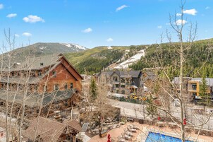 A mountainous village with wooden buildings and a ski slope.