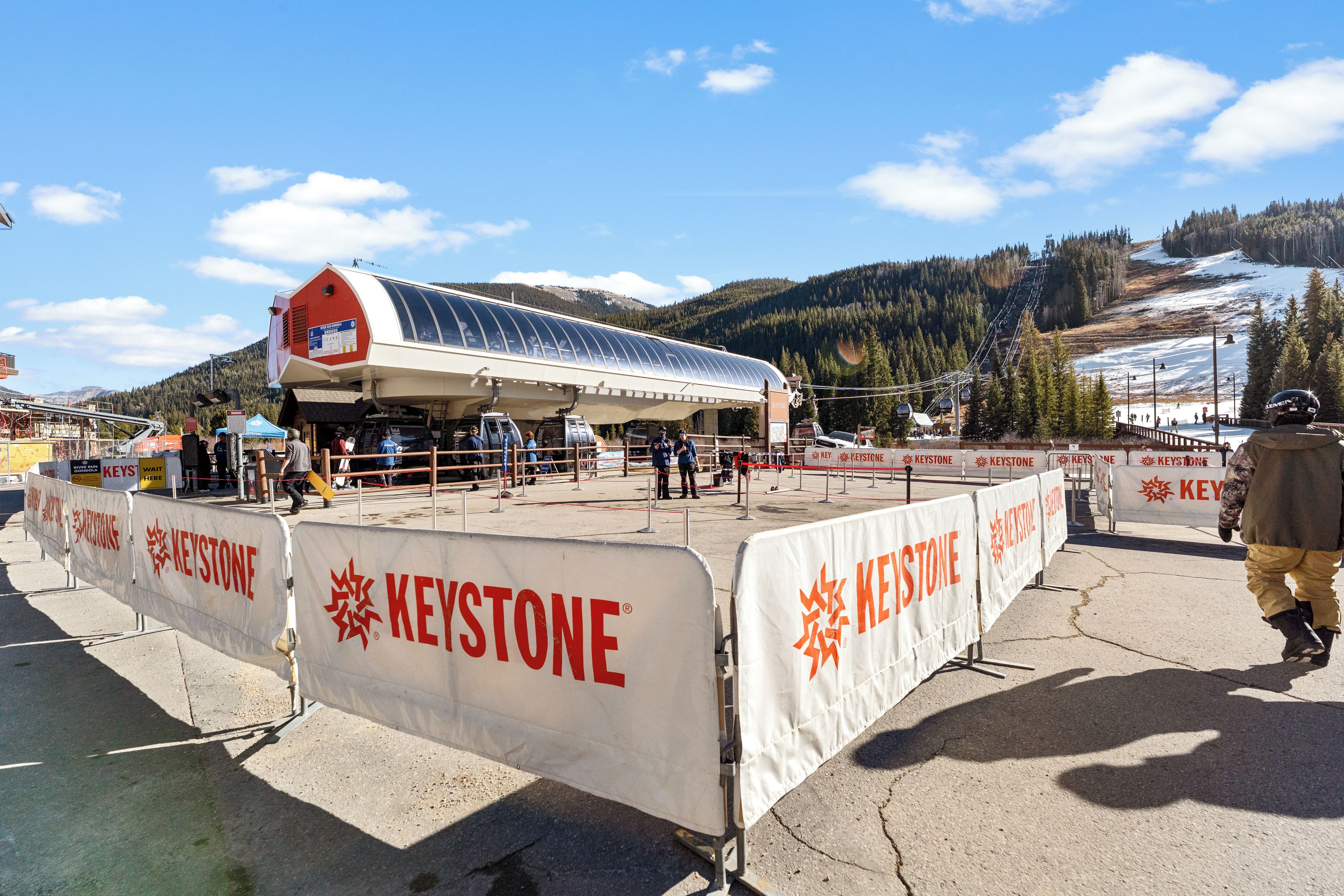 A ski resort with a large building, barriers, and a mountainous backdrop.