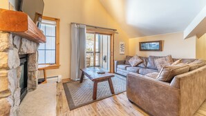 A cozy living room with a stone fireplace, a sofa, and a coffee table. - Dl8536-1 (Keystone)