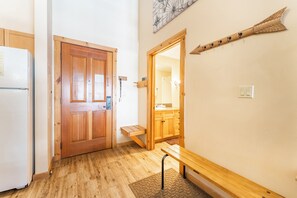 A hallway with a wooden door, a bench, and a wall-mounted coat rack. - Dl8536-1 (Keystone)