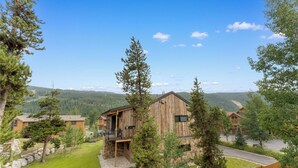 A rustic cabin with a balcony, surrounded by trees and a mountain view. - Snake River Village #29 (Keystone)