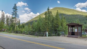 A lodge with a wooden cabin, a road with yellow lines, and a mountain backdrop. - Ski Tip #8723 : 2 (Keystone)