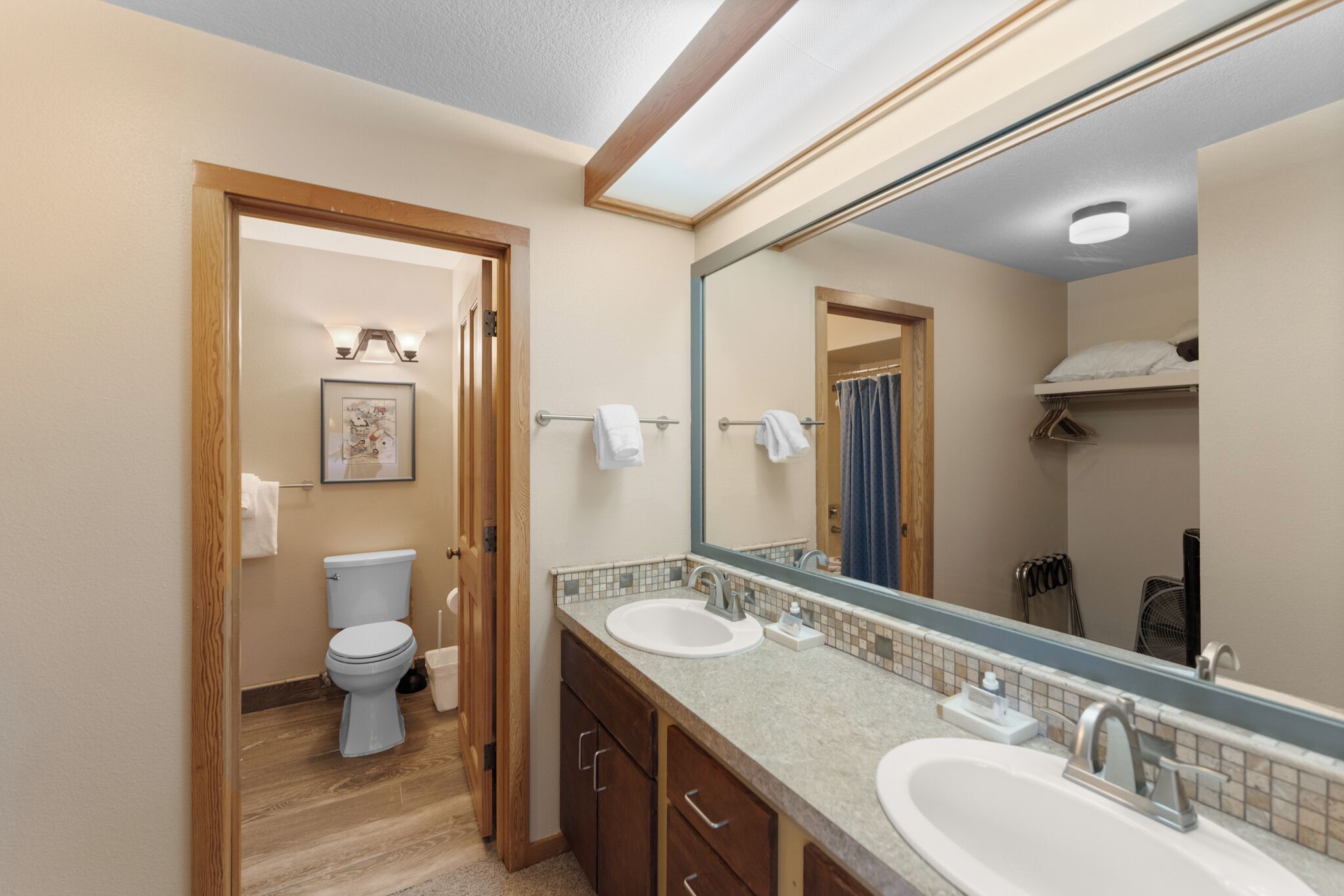 Un bagno con due lavandini, un water, uno specchio e una cabina doccia.