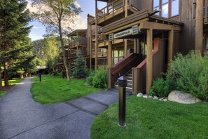 A lodge with multiple wooden balconies, a stone staircase, and a well-maintained garden.
